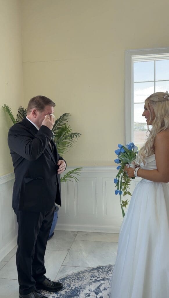 Bride sharing an emotional first look with her father as he wipes away tears before walking her down the aisle